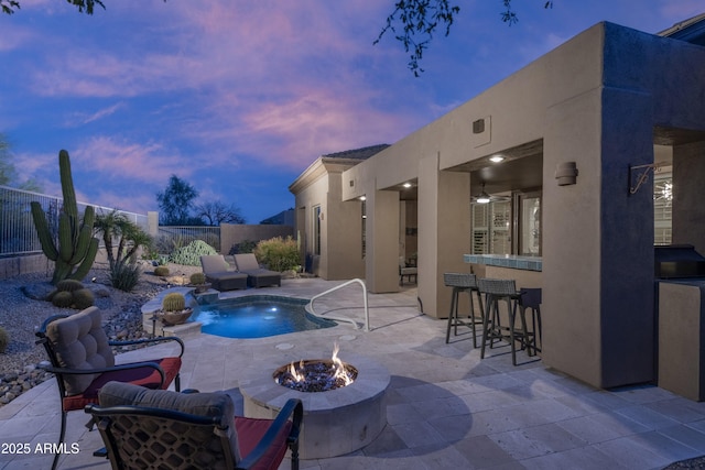 view of pool featuring outdoor dry bar, a fenced backyard, an outdoor living space with a fire pit, a fenced in pool, and a patio area