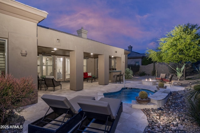 view of pool featuring fence, a patio, a fenced in pool, outdoor dry bar, and a fire pit
