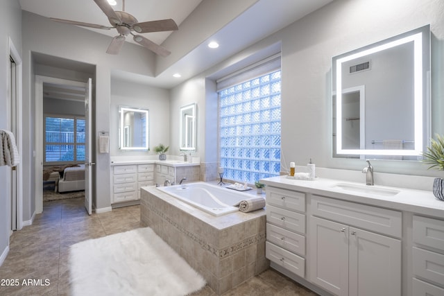 full bath featuring a sink, two vanities, a bath, visible vents, and ceiling fan