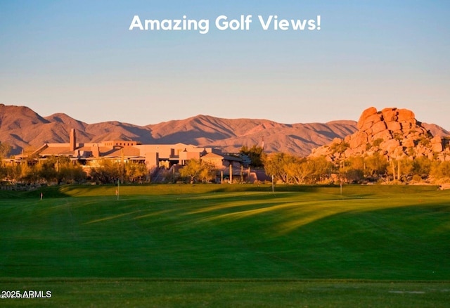 view of community with golf course view, a mountain view, and a yard