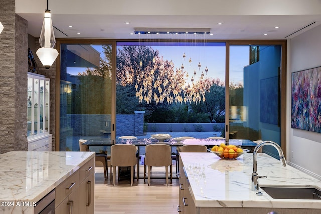 dining space with sink, beverage cooler, and light wood-type flooring