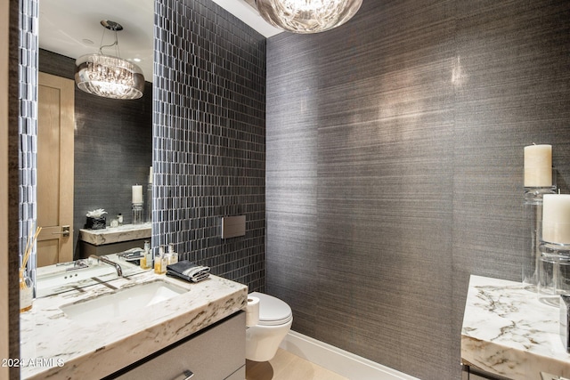 bathroom featuring vanity, toilet, and a chandelier