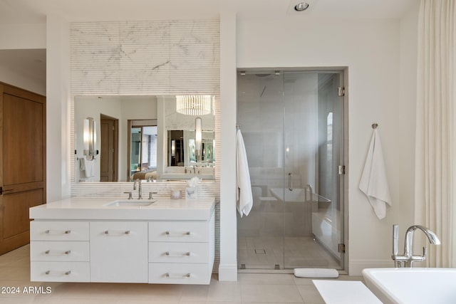 bathroom featuring plus walk in shower, vanity, and tile patterned flooring