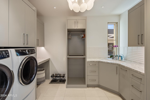 washroom with cabinets, independent washer and dryer, light tile patterned floors, and sink