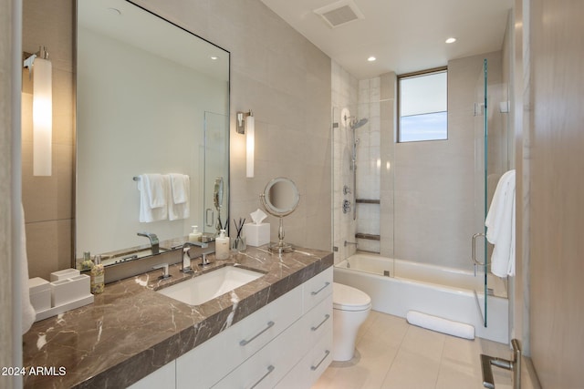 full bathroom with toilet, vanity, tile patterned floors, and enclosed tub / shower combo