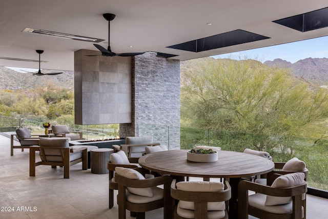 view of patio with a mountain view, an outdoor living space, and ceiling fan