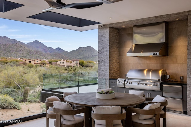 view of patio featuring a mountain view, area for grilling, ceiling fan, and an outdoor kitchen