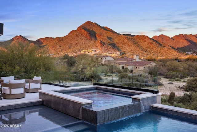 view of pool featuring a mountain view, pool water feature, and a jacuzzi