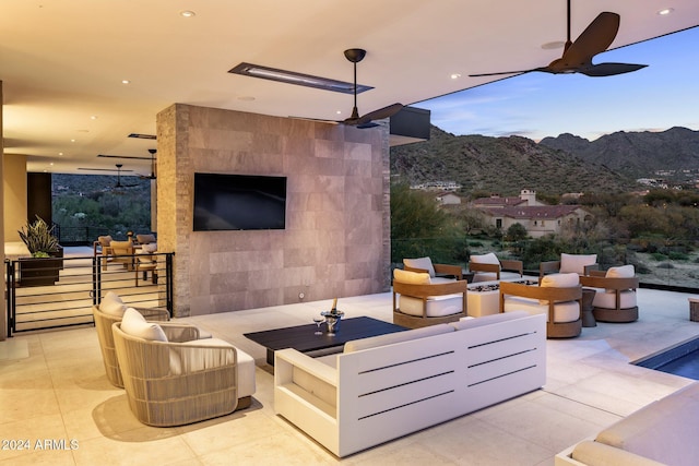 view of patio / terrace with an outdoor living space with a fireplace and ceiling fan