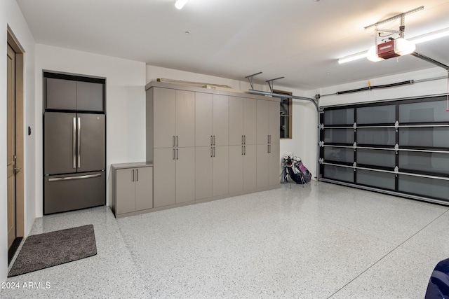 garage featuring stainless steel fridge and a garage door opener