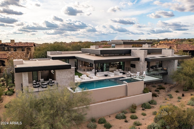 back of house with an outdoor living space and a patio