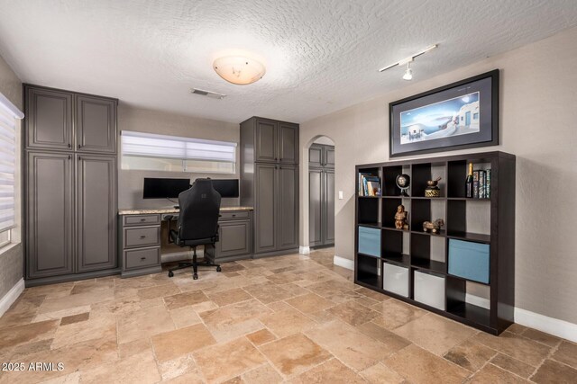 1751 W Mulberry Dr, Chandler, AZ 85286 - office featuring arched walkways, built in study area, stone tile floors, and a textured ceiling