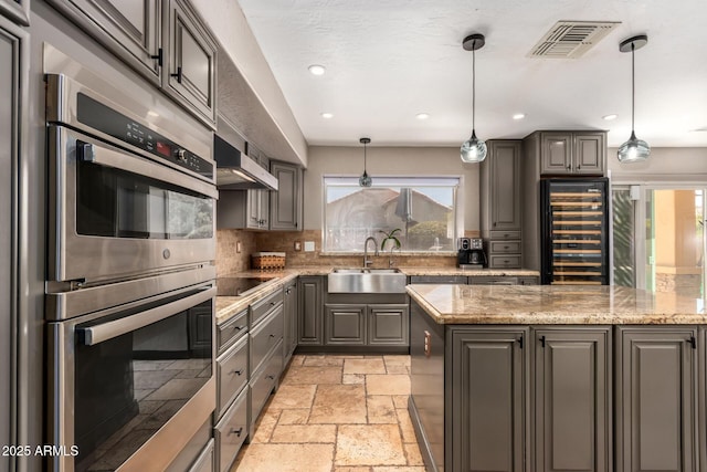 1751 W Mulberry Dr, Chandler, AZ 85286 - kitchen featuring wine cooler, stainless steel double oven, gray cabinetry, stone tile flooring, and wall chimney exhaust hood