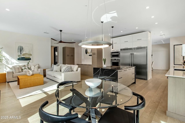 dining area featuring light wood finished floors, ceiling fan, and recessed lighting