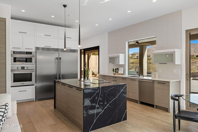 kitchen featuring light wood-type flooring, appliances with stainless steel finishes, and modern cabinets