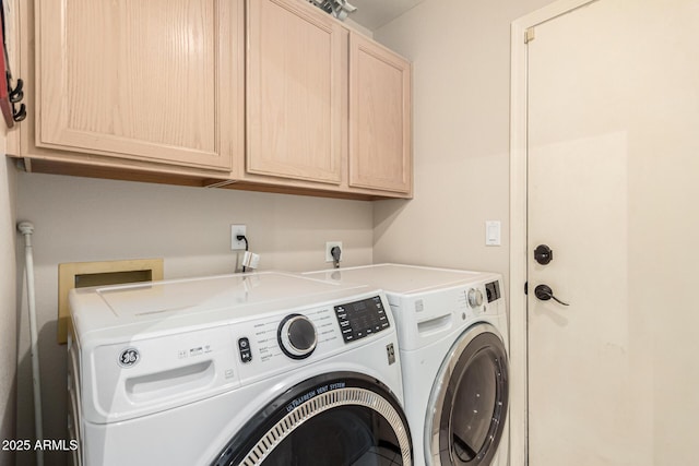 clothes washing area with cabinet space and washing machine and clothes dryer