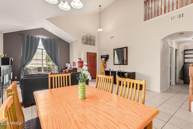 dining space featuring arched walkways, visible vents, baseboards, and light tile patterned flooring