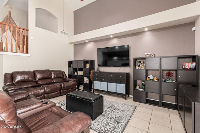 living area with light tile patterned floors, a high ceiling, and visible vents