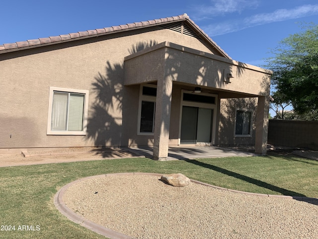 rear view of house featuring a lawn and a patio area