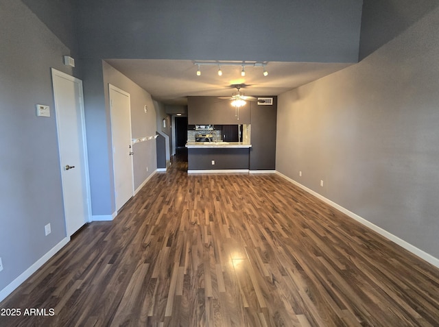 unfurnished living room featuring visible vents, a ceiling fan, dark wood-style flooring, and baseboards