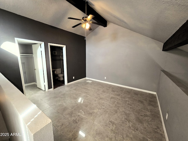 unfurnished bedroom with ceiling fan, a textured ceiling, vaulted ceiling with beams, and baseboards