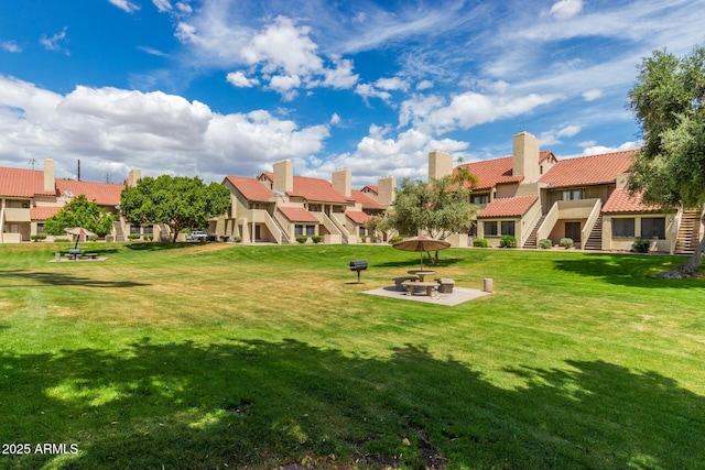 view of property's community with a patio, stairway, a lawn, and a residential view