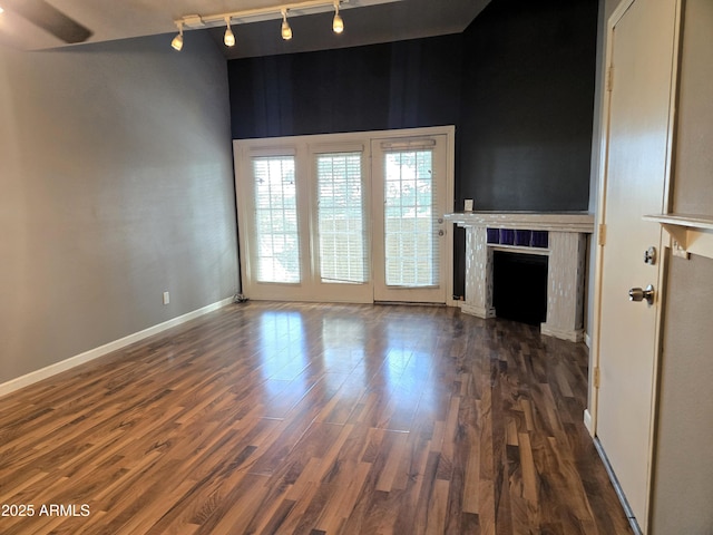 unfurnished living room with a fireplace, wood finished floors, and baseboards