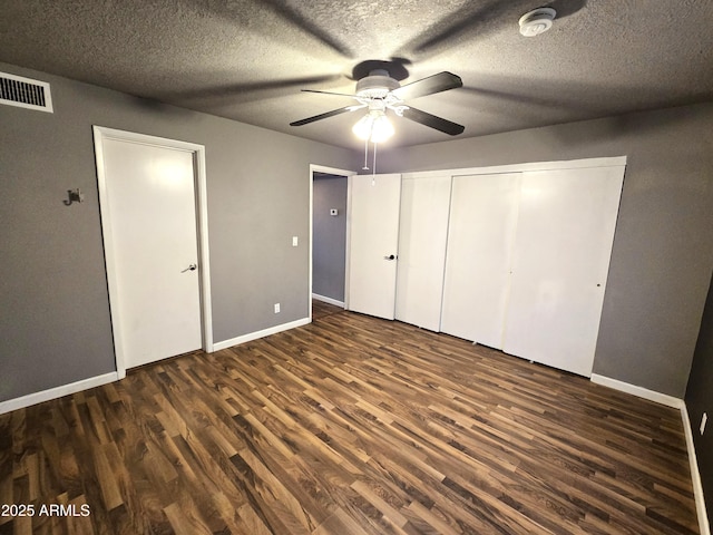 unfurnished bedroom featuring visible vents, baseboards, and wood finished floors