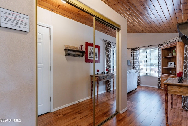 hall featuring vaulted ceiling, dark wood-type flooring, and wood ceiling