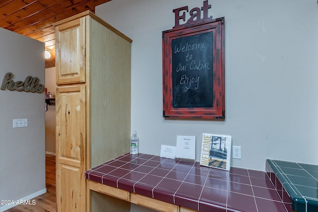 interior space with tile counters, wood ceiling, and dark hardwood / wood-style floors