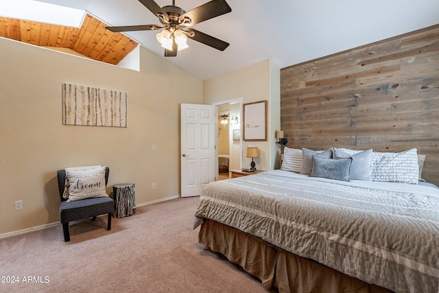 carpeted bedroom featuring a skylight, high vaulted ceiling, ceiling fan, and wooden ceiling