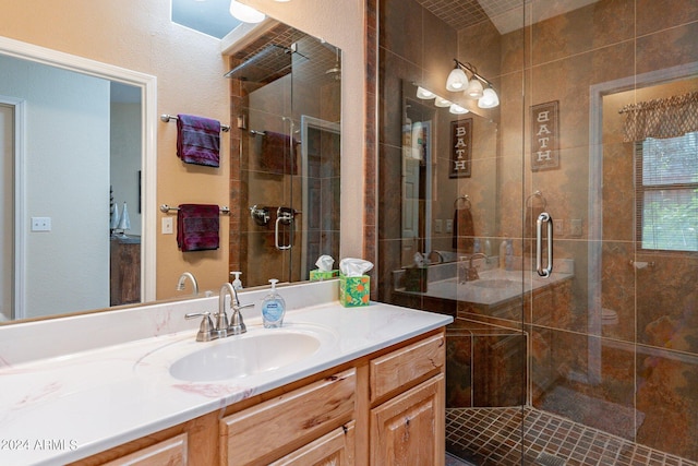 bathroom featuring a shower with door and vanity