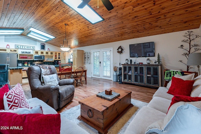 living room with wooden ceiling, vaulted ceiling with skylight, light hardwood / wood-style flooring, and ceiling fan