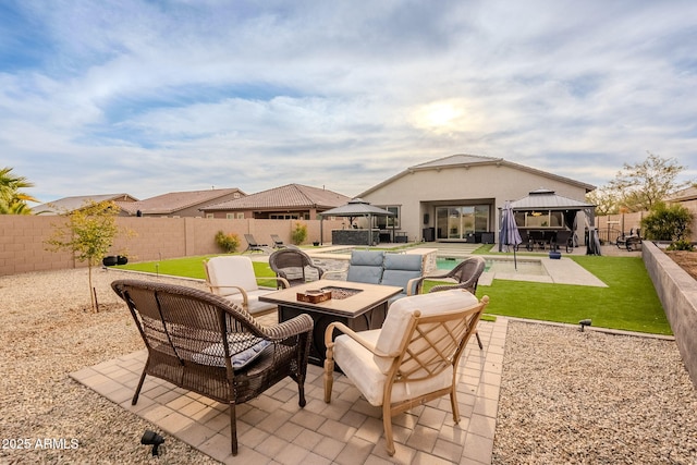 view of patio featuring a fire pit, a fenced in pool, and a gazebo