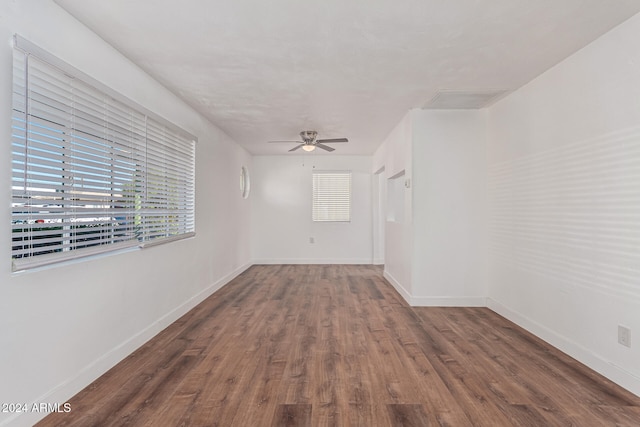 empty room with dark wood-type flooring and ceiling fan