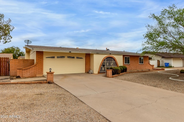 ranch-style house with an attached garage, fence, brick siding, and driveway