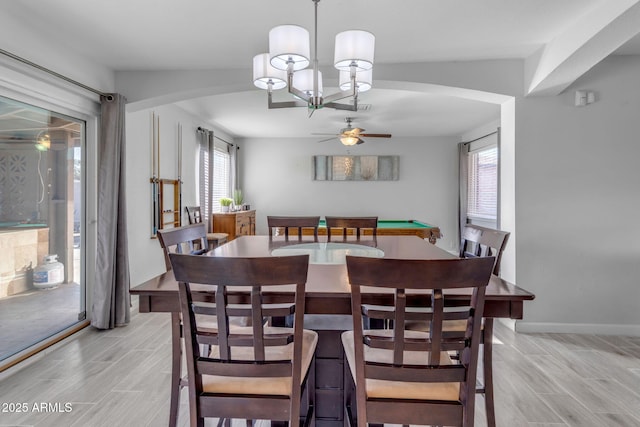 dining area featuring ceiling fan with notable chandelier