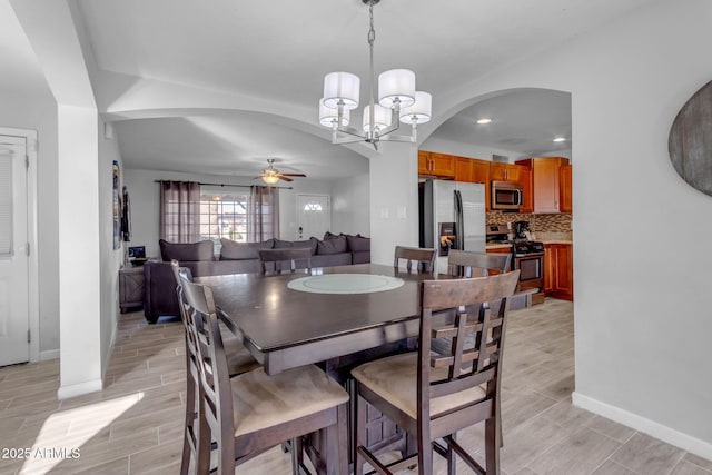 dining area with ceiling fan with notable chandelier