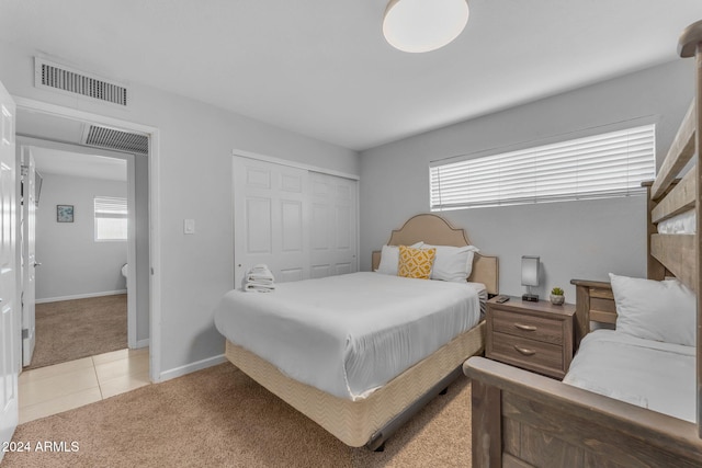 bedroom with light carpet and a closet