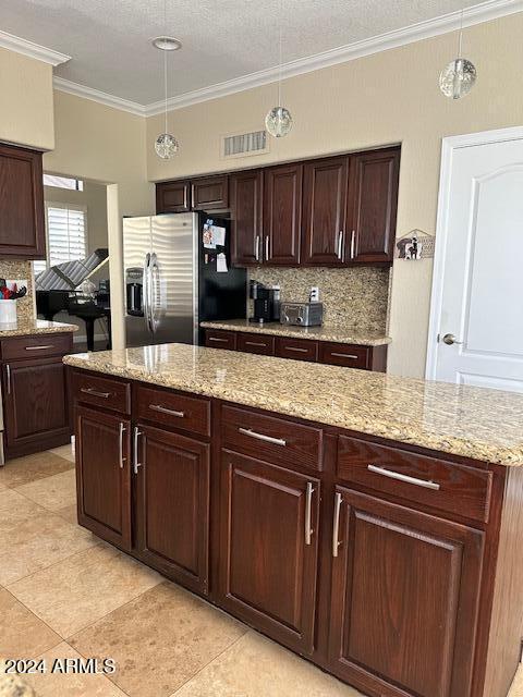 kitchen with decorative backsplash, stainless steel fridge, decorative light fixtures, and ornamental molding