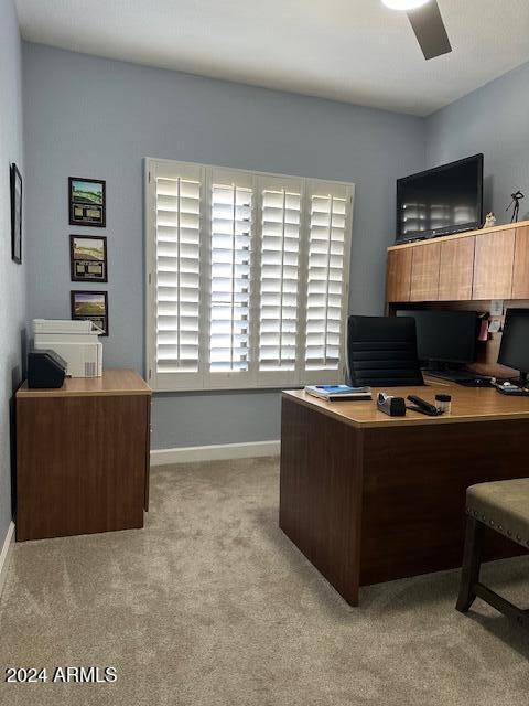 carpeted office space featuring ceiling fan