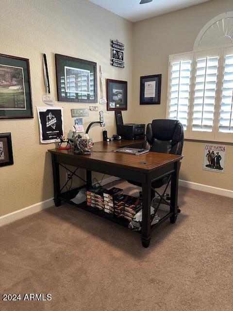 carpeted office space with ceiling fan