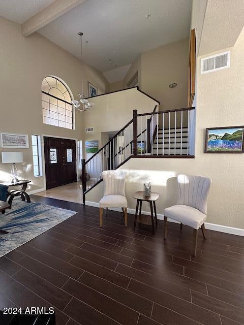 entryway with beamed ceiling, high vaulted ceiling, dark hardwood / wood-style floors, and an inviting chandelier