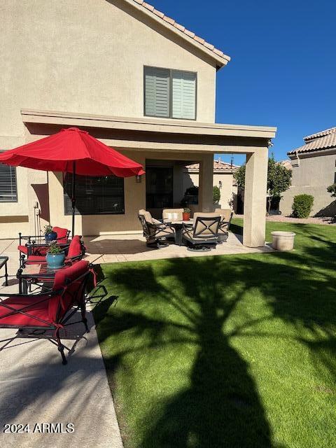 back of house with outdoor lounge area, a patio area, and a yard