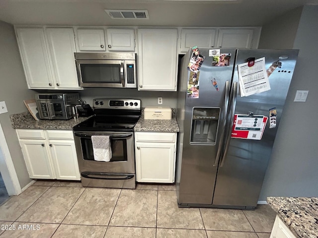 5143 W Mountain View Rd, Glendale, AZ 85302 - kitchen with appliances with stainless steel finishes, white cabinets, and light tile patterned flooring