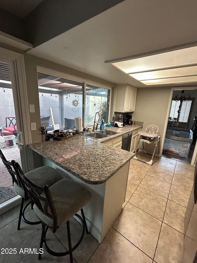 5143 W Mountain View Rd, Glendale, AZ 85302 - kitchen featuring a sink, a peninsula, stainless steel dishwasher, a kitchen breakfast bar, and light tile patterned flooring