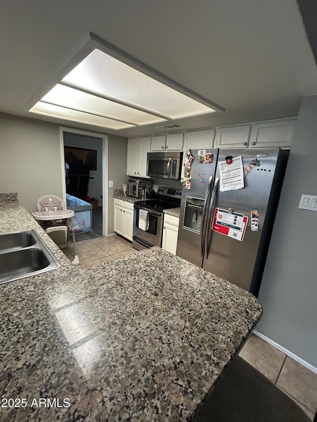 5143 W Mountain View Rd, Glendale, AZ 85302 - kitchen with stainless steel appliances, light tile patterned floors, white cabinetry, and a sink