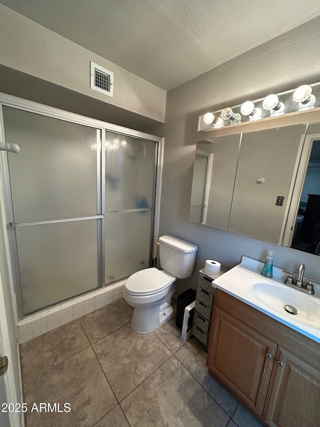 5143 W Mountain View Rd, Glendale, AZ 85302 - full bathroom with vanity, toilet, a shower stall, tile patterned flooring, and a textured ceiling