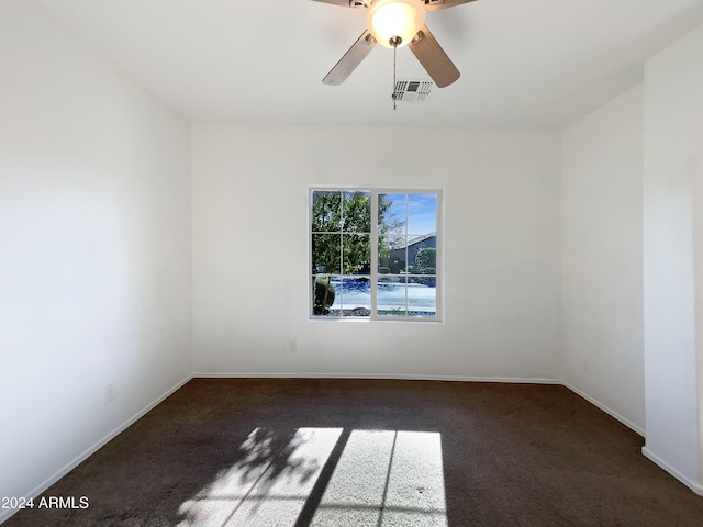 empty room with dark carpet and ceiling fan