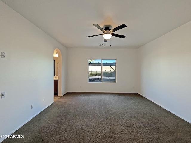 unfurnished room featuring ceiling fan and dark colored carpet